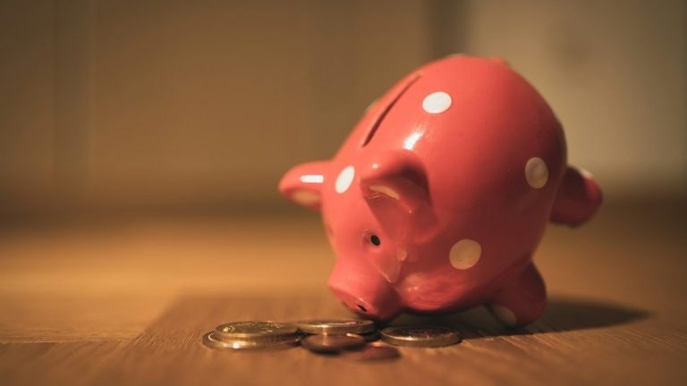 A polka-dot piggy bank with a little house fund