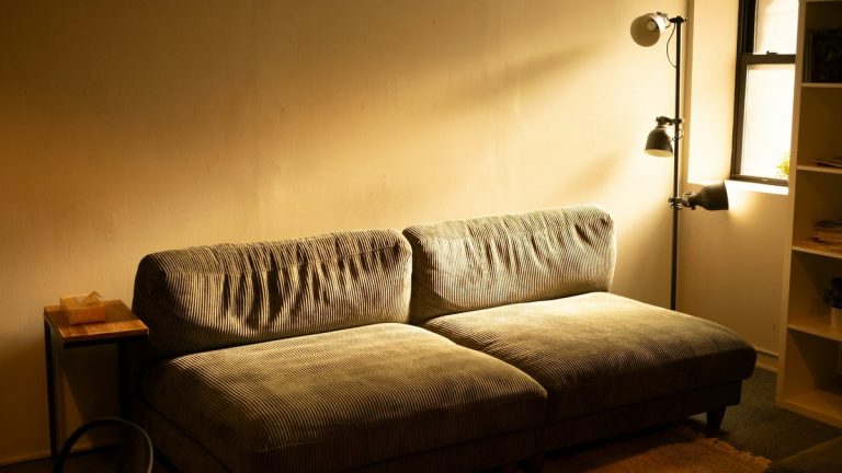 A comfortable sofa bathed in warm lamp light.