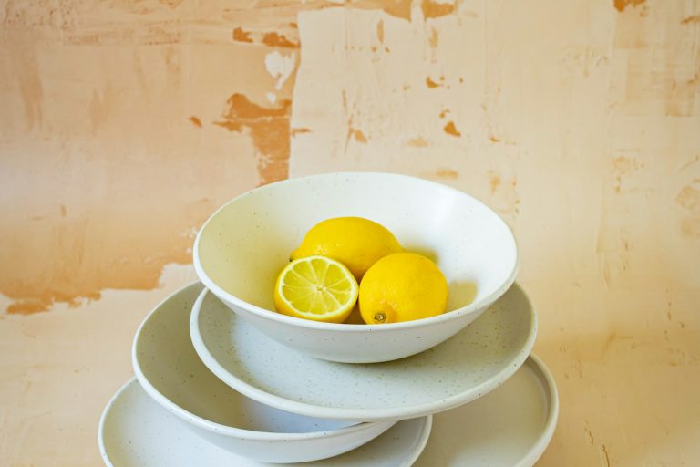 Bright yellow lemons arranged in white kitchen dishes