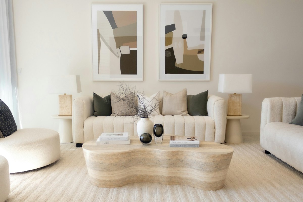 An elegant neutral living room styled with paired artwork and sculptural accessories