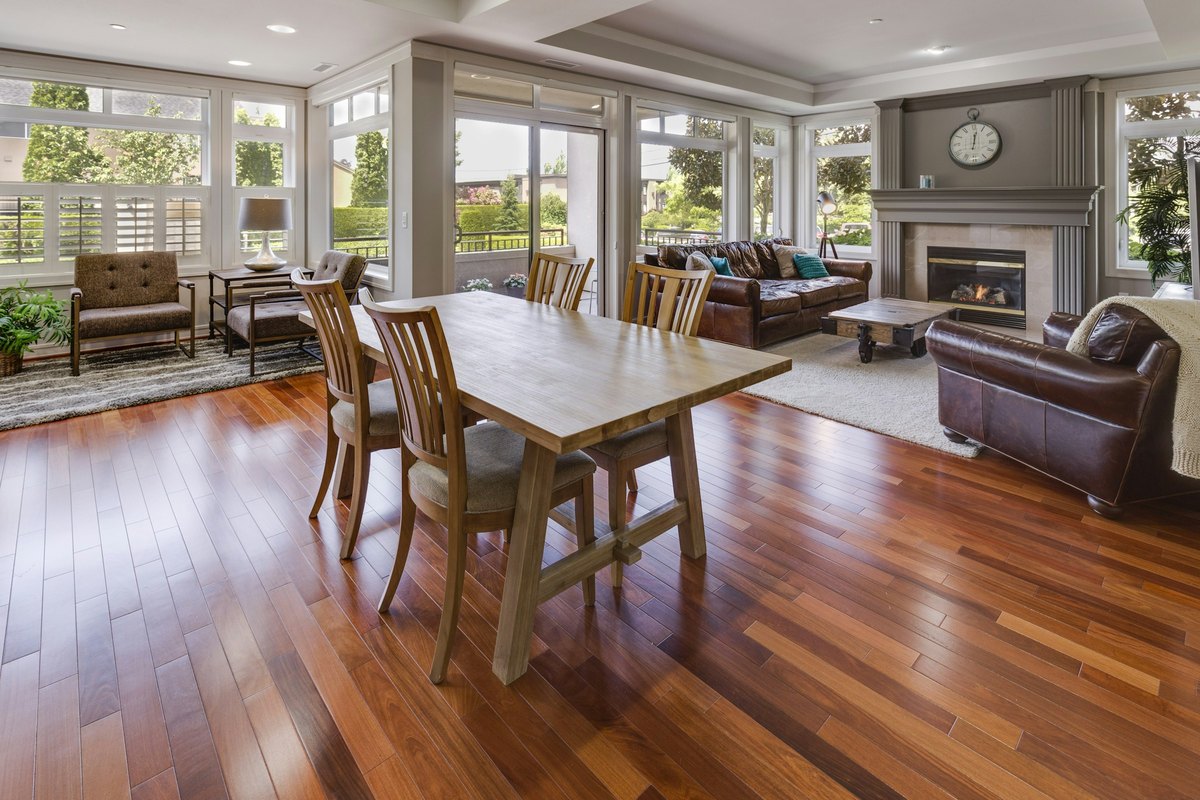 Gleaming wood flooring running through an open living and dining room