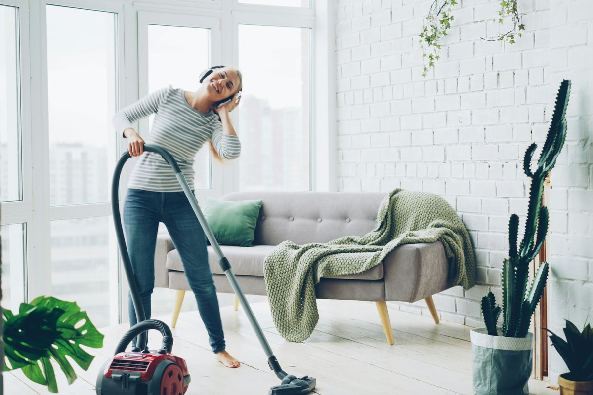 A woman vacuuming a bright modern living room