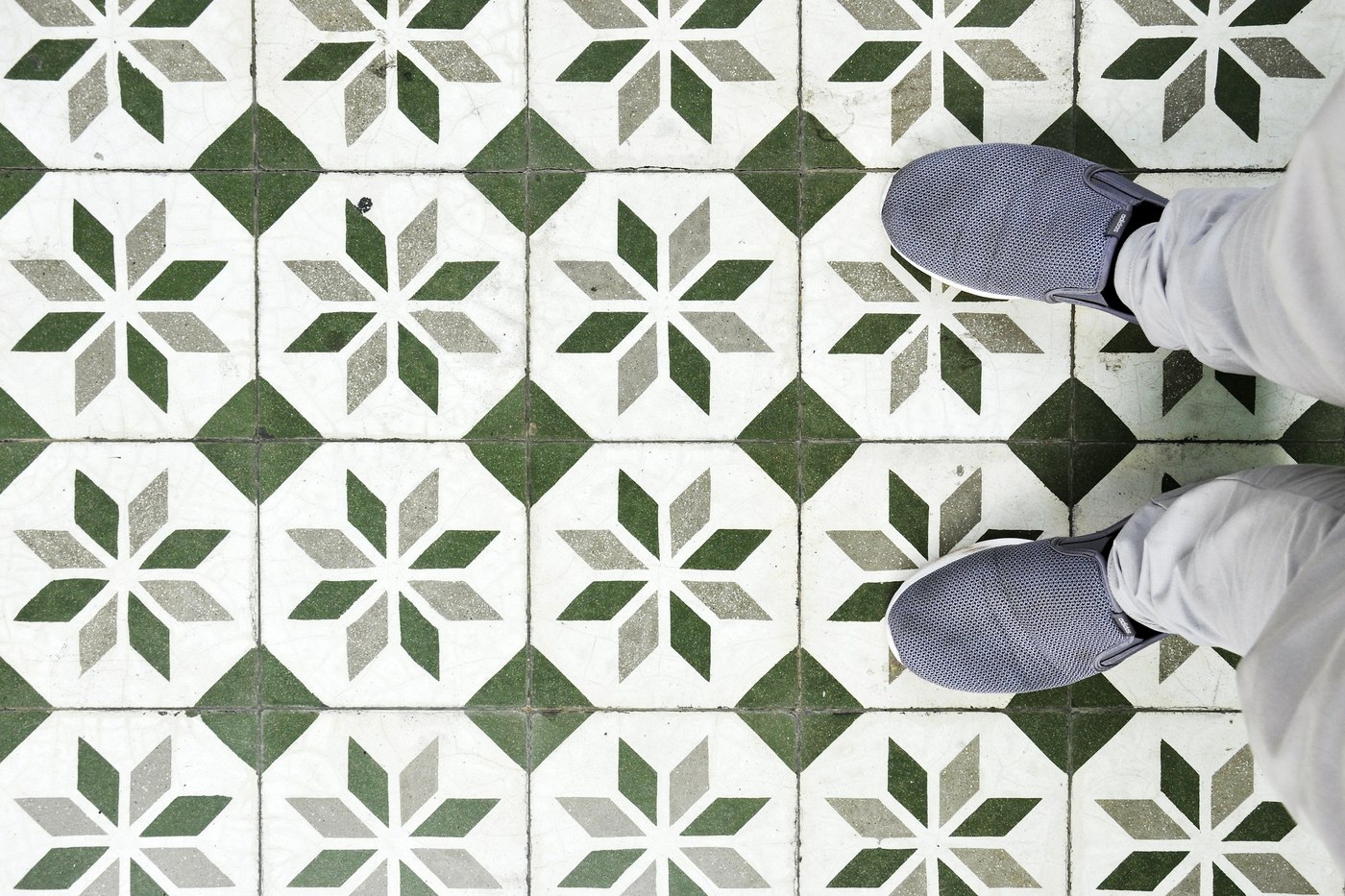 Person standing on green and white patterned tile flooring