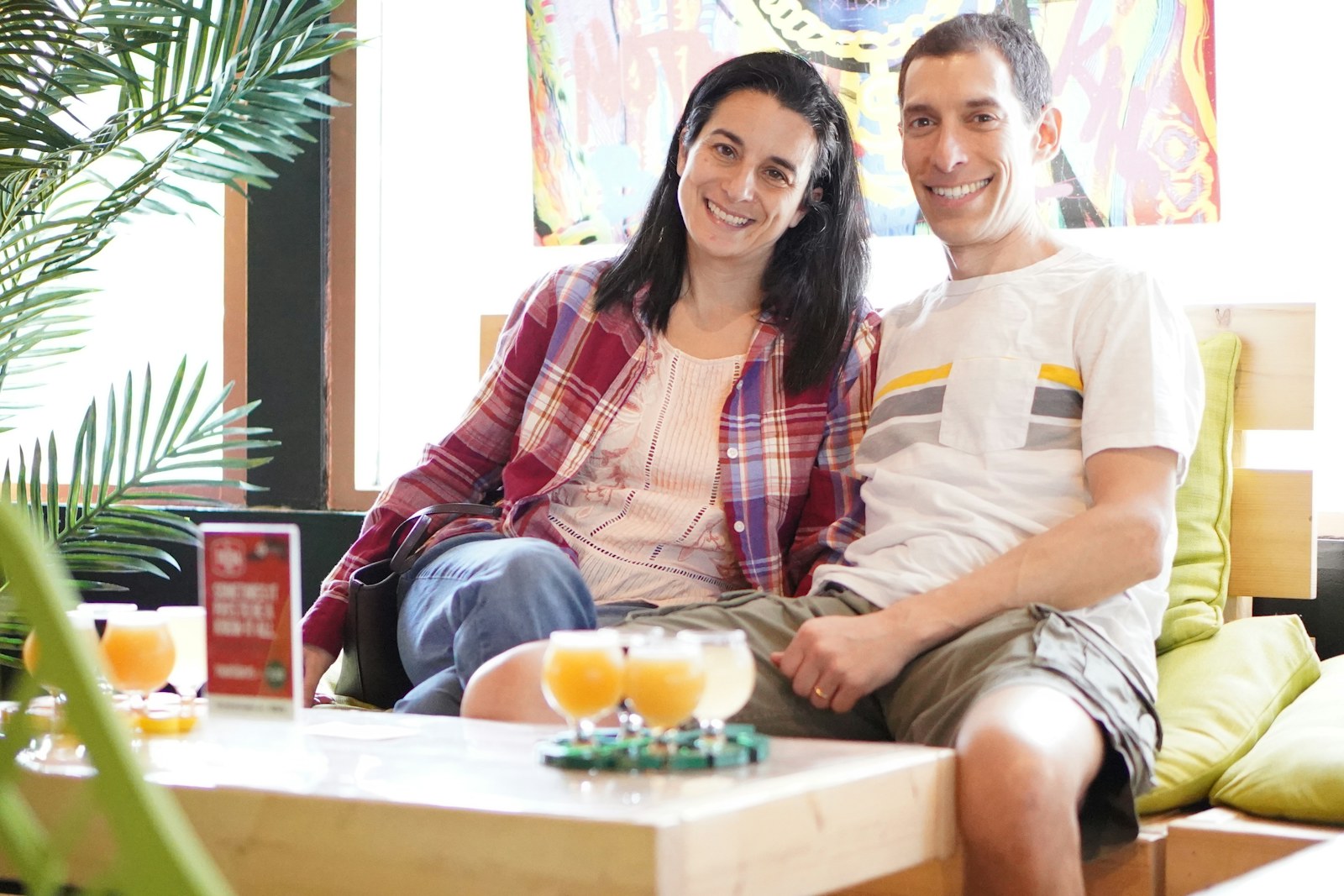 Couple sitting together on a bright couch with juice on the table